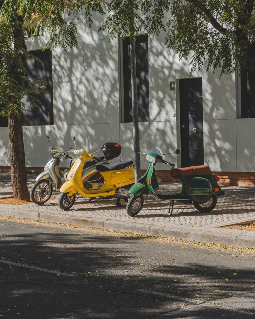 Open park-and-ride car park on the outskirts of Seville with several rows of parked cars