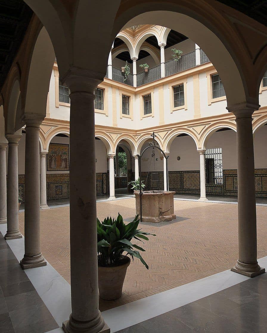 Cloister of the Museo de Bellas Artes in Seville with arches, tiles and a planted courtyard in the centre