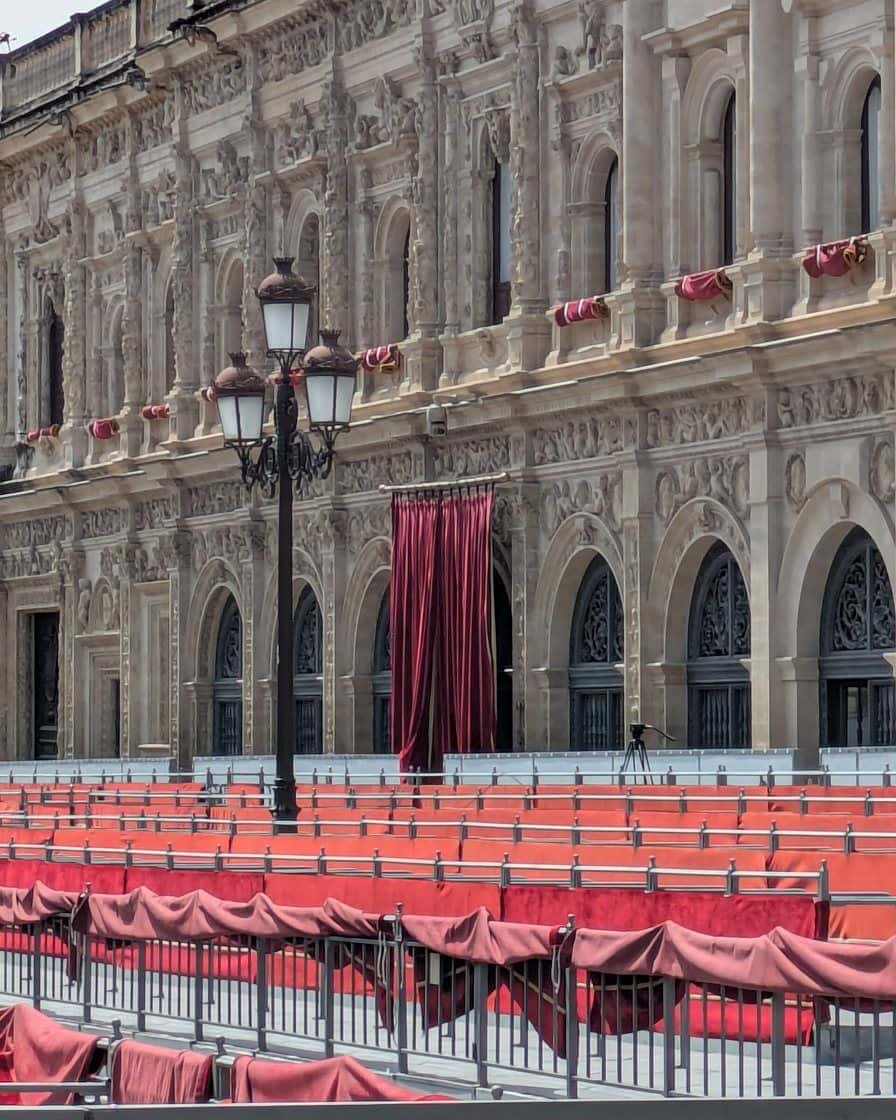 Stretch of the Carrera Oficial of Seville's Holy Week in front of the Cathedral, with stands of empty chairs before a procession