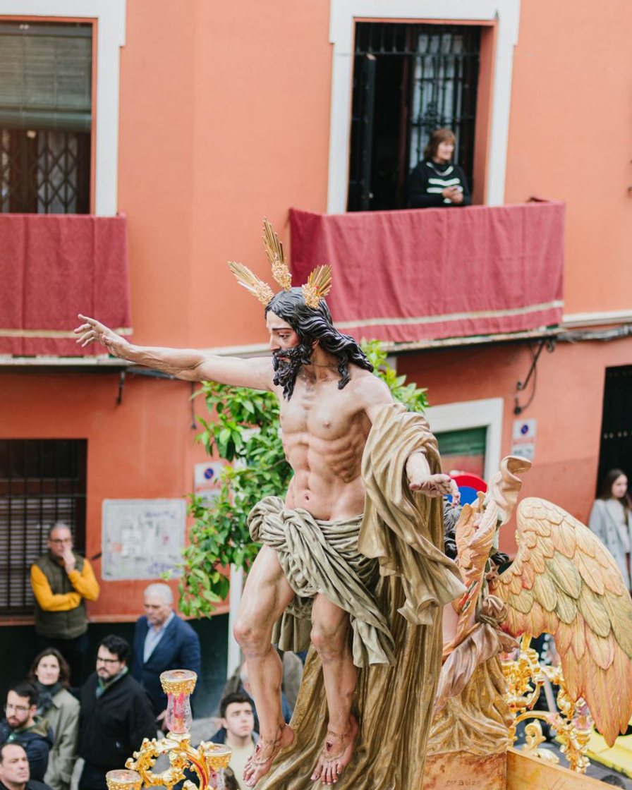 Programa de mano de la Semana Santa de Sevilla abierto sobre una mesa de bar, con el plano del recorrido y las horas de paso señaladas a bolígrafo