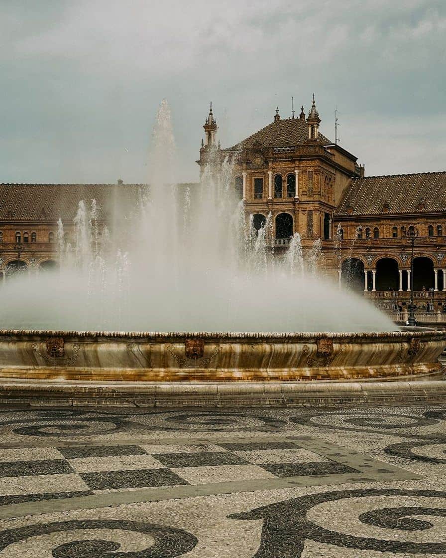 Central fountain of Plaza de España in Seville with the semicircular building behind, on a clear morning