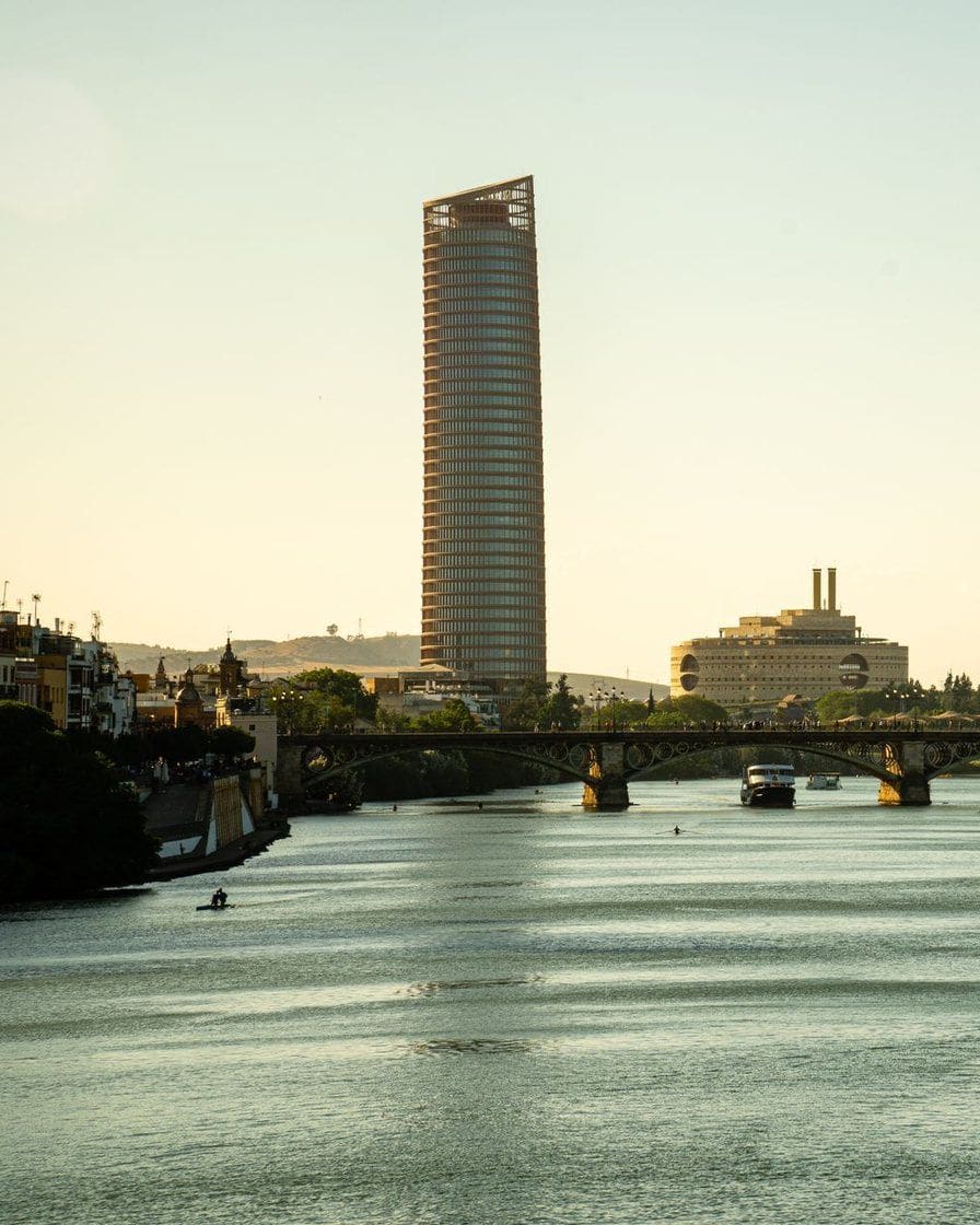 Pont de Triana à Séville vu depuis la berge, avec la Giralda qui dépasse au fond au-dessus de la ville