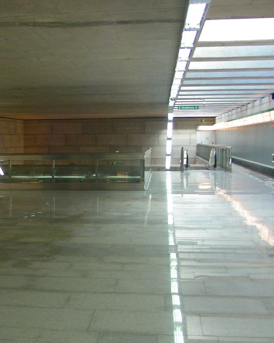 Puerta Jerez metro entrance in Seville at night, with Holy Week barriers and people walking towards the Avenida de la Constitución
