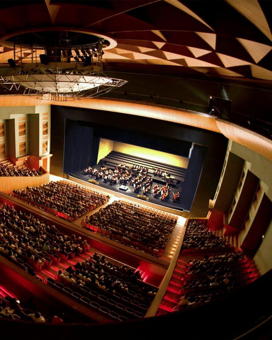 Interior of a theatre with horseshoe seating seen from the stage before a formal event, with no audience