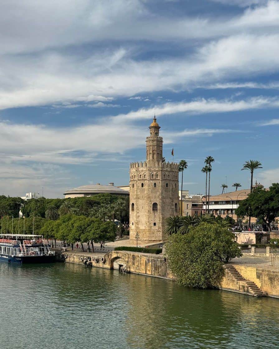 Torre del Oro in Seville beside the Guadalquivir, with an empty riverside promenade in the foreground at sunset